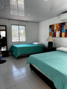 a bedroom with two beds and a window at Casa Cortijos in Valledupar +8 photos