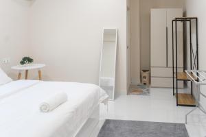 a white bedroom with a bed and a table at Deam Stay in Kulhudhuffushi