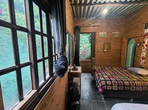 a bedroom with a bed and windows in a cabin at CHÁCARA dos CHEIROS in Atibaia +43 photos