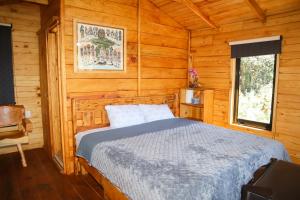 a bedroom with a bed in a wooden cabin at Casas Calenda in San Mateo Río Hondo
