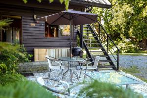 a table and chairs with an umbrella in front of a house at Lucky's Hostel in Pucón +35 photos