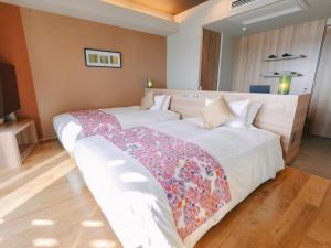 a hotel room with two beds in a room at Senagajima Island Resort & Spa in Tomigusuku