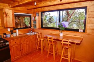 a kitchen with a wooden counter and a table with stools at Casas Calenda in San Mateo Río Hondo