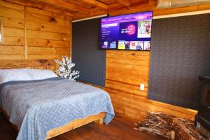 a bedroom with a bed and a tv on the wall at Casas Calenda in San Mateo Río Hondo