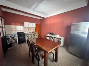 a kitchen with a wooden table and a refrigerator at Casa Alfonso 4 huéspedes y cochera gratis in Humahuaca +6 photos