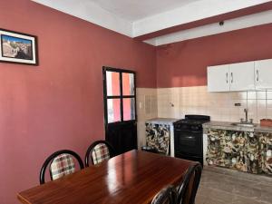 a kitchen with a wooden table and a dining room at Casa Alfonso 4 huéspedes y cochera gratis in Humahuaca