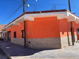 an orange and white building on the side of a street at Casa Alfonso 4 huéspedes y cochera gratis in Humahuaca