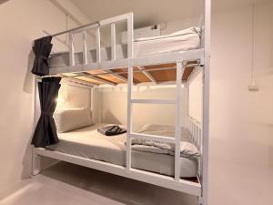 a bunk bed in a room with white bunk beds at Bingo Hostel Khao Sok in Khao Sok National Park