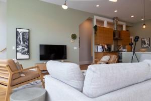 a living room with a white couch and a tv at Gorgeous 5BR Storefront Home ABODEbucks in Soulard