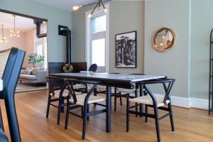a dining room with a black table and chairs at Gorgeous 5BR Storefront Home ABODEbucks in Soulard +42 photos