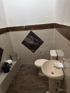 a bathroom with a white toilet and a sink at Complejo Residencial Las Lomitas in San Lorenzo de la Frontera +16 photos