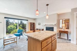 a kitchen with a large island in a living room at Third-floor riverfront condo near downtown Bend in Bend