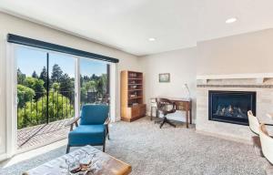 a living room with a fireplace and a desk at Third-floor riverfront condo near downtown Bend in Bend