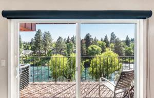 a sliding glass door with a chair on a balcony at Third-floor riverfront condo near downtown Bend in Bend +27 photos