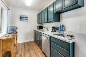 a kitchen with green cabinets and a counter top at Riverside Cottage - Just Steps from the Deschutes in Bend
