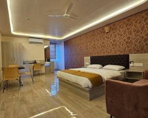 a bedroom with a bed and a desk and a kitchen at New KR Inn in Mālūr
