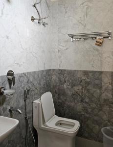 a bathroom with a toilet and a sink at New KR Inn in Mālūr