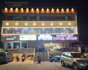 a building with cars parked in a parking lot at New KR Inn in Mālūr