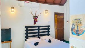 a bedroom with a bed and a painting on the wall at Bliss Cottage in Gampola