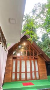 a small wooden house with a large window at Bliss Cottage in Gampola