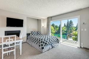 a bedroom with a bed and a desk and a window at Downtown Condo with Riverview & Balcony in Bend +32 photos