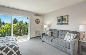 a living room with a couch and a balcony at Downtown Condo with Riverview & Balcony in Bend