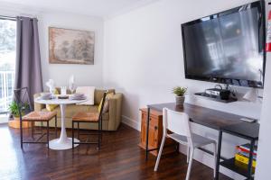 a living room with a dining room table and a tv at Wanderlust Studio Suite with Private Patio in Harrison Hot Springs