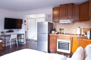 a kitchen with a stainless steel refrigerator and wooden cabinets at Wanderlust Studio Suite with Private Patio in Harrison Hot Springs