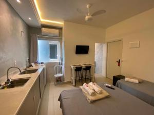 a kitchen with a sink and a couch in a room at Hotel kitnet Digital in Passos