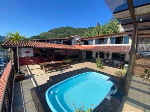 an outdoor swimming pool in front of a house at Cobertura luxuosa Marambaia in Barra de Guaratiba +16 photos