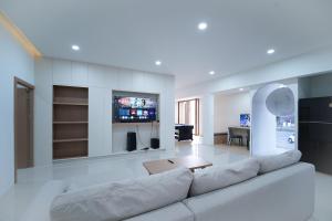 a living room with a couch and a tv at Villa LaMoon in Sattahip
