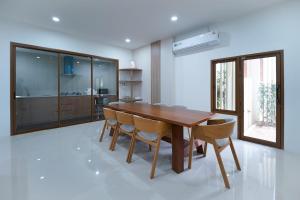 a dining room with a wooden table and chairs at Villa LaMoon in Sattahip