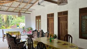 a dining room with a table and chairs at HideWay Guest House Midigama in Midigama East