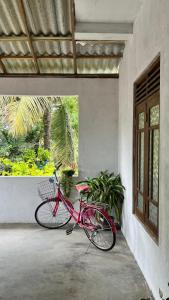 a red bike parked on the side of a building at HideWay Guest House Midigama in Midigama East