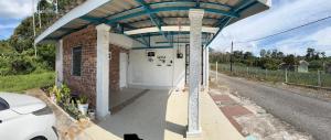 a building with a garage on the side of a road at IdaSari Guest House Bukit Bunga in Kampong Bukit Bunga