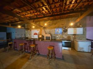 a kitchen with a bar and stools in a room at Cobertura luxuosa Marambaia in Barra de Guaratiba