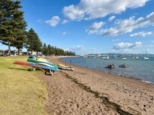 a beach with boats and people on the water at Pet friendly downtown Mt Maunganui 3 bedroom home in Mount Maunganui