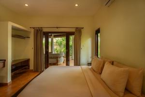 a bedroom with a large bed in a room at Flor Villa by Betterplace in Dalung +13 photos