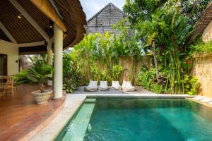 a swimming pool in front of a house at Flor Villa by Betterplace in Dalung