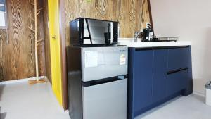 a kitchen with a refrigerator and a microwave at Gyeongju raon glamping in Samgong
