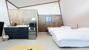 a hotel room with two beds and a sink at Gyeongju raon glamping in Samgong
