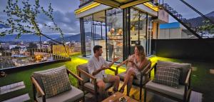 a man and woman sitting on the balcony of a building at El Camino De Diego in Otavalo