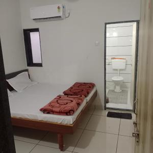 a small bedroom with a bed and a toilet at Keshav femely banglow in Dwarka