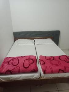 two beds sitting next to each other in a room at Keshav femely banglow in Dwarka