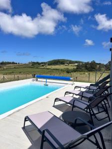 a group of chairs sitting next to a swimming pool at Chacra Piriápolis in Piriápolis