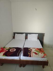 two beds sitting next to each other in a room at Keshav femely banglow in Dwarka