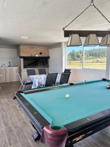 a pool table in a living room with a table at Chacra Piriápolis in Piriápolis
