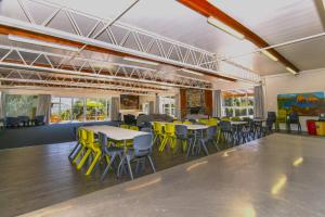 a room with tables and yellow chairs in it at Rotoiti Lodge in Saint Arnaud