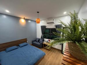 a bedroom with a blue bed and a plant at Shang Hotel in Uoc Le (1)