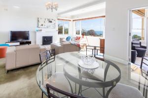 a living room with a glass table and chairs at Beach Belle Mornington in Mornington +8 photos